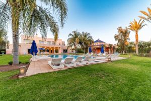 a row of lounge chairs next to a swimming pool at Palais Pyar Luxury and Serenity Setting in Najem