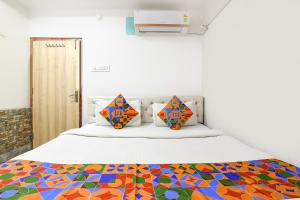 a bedroom with a bed with a colorful bedspread at FabHotel Continental in kolkata