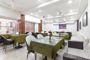 a restaurant with tables and chairs in a room at FabHotel Continental in kolkata