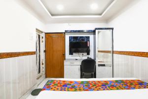 a bedroom with a bed and a desk and a television at FabHotel Continental in kolkata