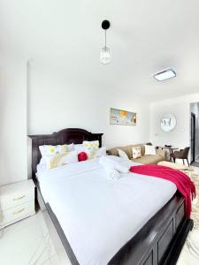 a bedroom with a large bed with white sheets at The Kilimani Executive Studio Haven with Gym&Restaurant in Nairobi