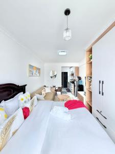 a large white bed in a room with a living room at The Kilimani Executive Studio Haven with Gym&Restaurant in Nairobi