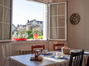 a dining room with a table and a large window at Casa Mayra in Camargo