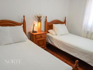 a bedroom with two beds and a lamp on a night stand at Casa Mayra in Camargo