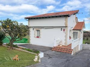 a white house with a tree and a yard at Casa Mayra in Camargo
