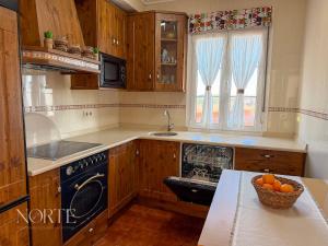 a kitchen with wooden cabinets and a bowl of oranges on the counter at Casa Mayra in Camargo +18 photos