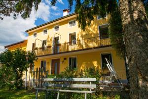 a white bench in front of a yellow building at Casa dei Nonni in Mirabella