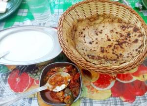 a table with a bowl of food and a basket of food at The Hostelers Homestay Shimla - Near ISBT, Bypass MC Parking and HPU in Shimla