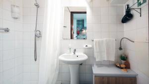 a white bathroom with a sink and a mirror at A Casa dos Avós in Pêra +43 photos