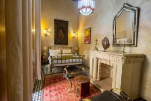 a living room with a fireplace and a bed at Riad Sarasvati & SPA in Marrakesh
