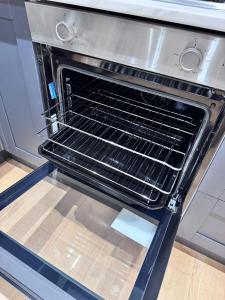 an oven with an empty rack inside of it at Modern 4 Bedroom House Sleeps 10 Free Parking Liverpool in Litherland +70 photos