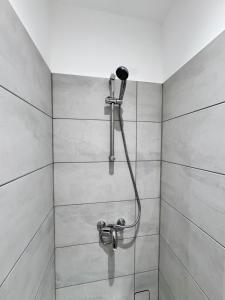 a shower with a shower head in a bathroom at Modern 4 Bedroom House Sleeps 10 Free Parking Liverpool in Litherland