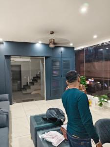 a man standing in a living room with a table at hotel apple tree in Bahādurgarh