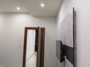 a hallway with a mirror and a television on a wall at hotel apple tree in Bahādurgarh