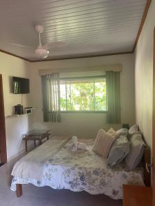 a bedroom with a large bed with a window at Refúgio em São Pedro da Serra in Nova Friburgo +103 photos