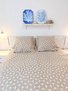 a bed with two blue vases on a wall at cozy flat in Puerto del Rosario