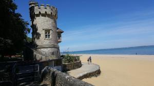 two people walking on a beach next to a castle at Warm, Sleeps 6, Bathroom, Beaches Shops Cafes Bars Pier, Central Ryde in Ryde