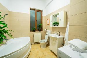 a bathroom with a tub and a toilet and a sink at Pit Stop Centrum in Ploieşti +5 photos