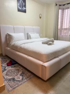a large white bed sitting in a room at LionsGate Homes in Nakuru