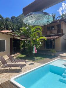 a villa with a swimming pool and a house at Refúgio em São Pedro da Serra in Nova Friburgo