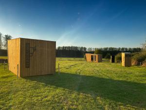 a couple of small buildings in a field at Cyclodges – Marguerite et Ferdinand in Hotton