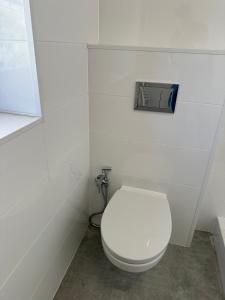a white toilet in a white bathroom with a sink at Mieszkateria in Piotrków Trybunalski