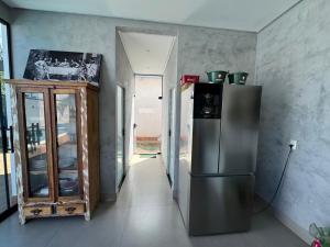 a kitchen with a stainless steel refrigerator in a room at Espaço completo MOTO GP in Aparecida de Goiânia