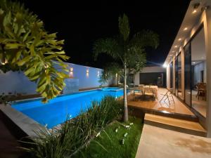 a house with a swimming pool at night at Espaço completo MOTO GP in Aparecida de Goiânia