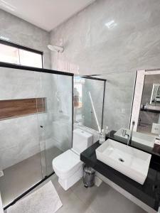 a bathroom with a toilet and a sink and a shower at Espaço completo MOTO GP in Aparecida de Goiânia +15 photos
