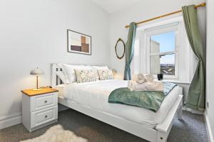 a bedroom with a white bed and a window at Wolfe Tone Apartment 2 in Sligo