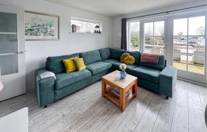 a living room with a green couch and a table at Holiday Home Breukelen Iv in Breukelen