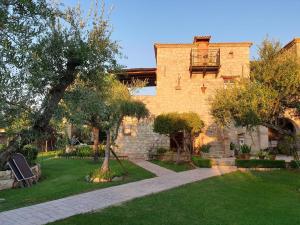 a large brick building with a tree in the yard at Grantzaos Villas in Laganas