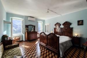a bedroom with a large wooden bed and blue walls at Albergo Diffuso Ca' Spiga in Laglio