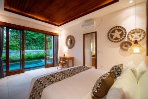a bedroom with a large bed and a large window at Yoga Sri Ubud Hotel & Spa in Ubud +60 photos