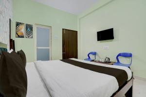 a bedroom with a bed and two blue chairs at Hotel O Dhauli Inn in Pānchagān