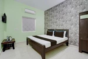 a bedroom with a bed and a wall at Hotel O Dhauli Inn in Pānchagān
