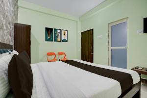 a bedroom with a large bed and two orange chairs at Hotel O Dhauli Inn in Pānchagān