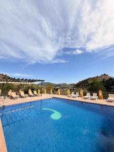 a large swimming pool with chairs and a view of the ocean at Caserio de Iznájar in Iznájar