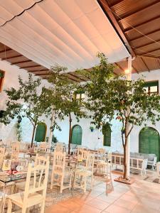 a room with tables and chairs and a tree at Caserio de Iznájar in Iznájar