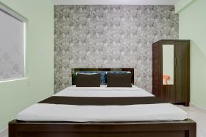 a bedroom with a bed and a wall at Hotel O Dhauli Inn in Pānchagān