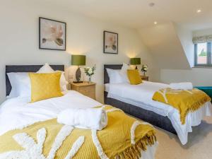 two beds in a bedroom with yellow and white at 2 Bed in Newton Tracey oc-80381 in Bishops Tawton