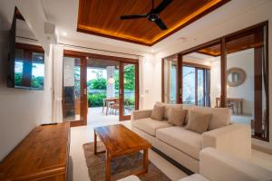 a living room with a couch and a table at Yoga Sri Ubud Hotel & Spa in Ubud