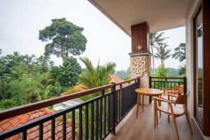 a balcony with a table and a view of the jungle at Yoga Sri Ubud Hotel & Spa in Ubud