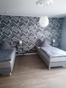 a bedroom with two beds and a accent wall at Tinas Fewo 2 in Hohendodeleben
