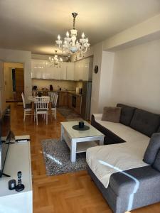 a living room with a couch and a table at Venus Deluxe Apartment in Strumica +32 photos