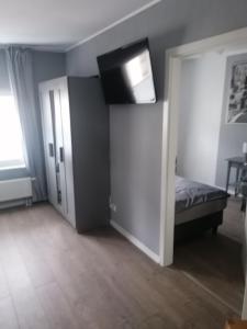 a room with a bed and a television on the wall at Tinas Fewo 2 in Hohendodeleben