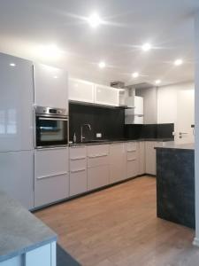 a kitchen with white cabinets and a black counter top at Tinas Fewo 2 in Hohendodeleben