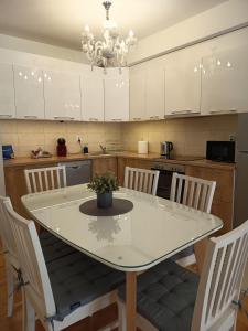 a kitchen with a table with chairs and a chandelier at Venus Deluxe Apartment in Strumica