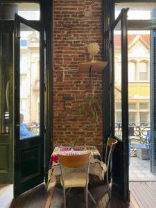 a table and chairs in a room with a brick wall at Freedom Hostel in Rosario