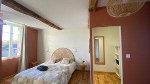 a bedroom with a large bed with pink walls at Chambre Terracotta privée et accès jacuzzi - sauna in Lézat-sur-Lèze